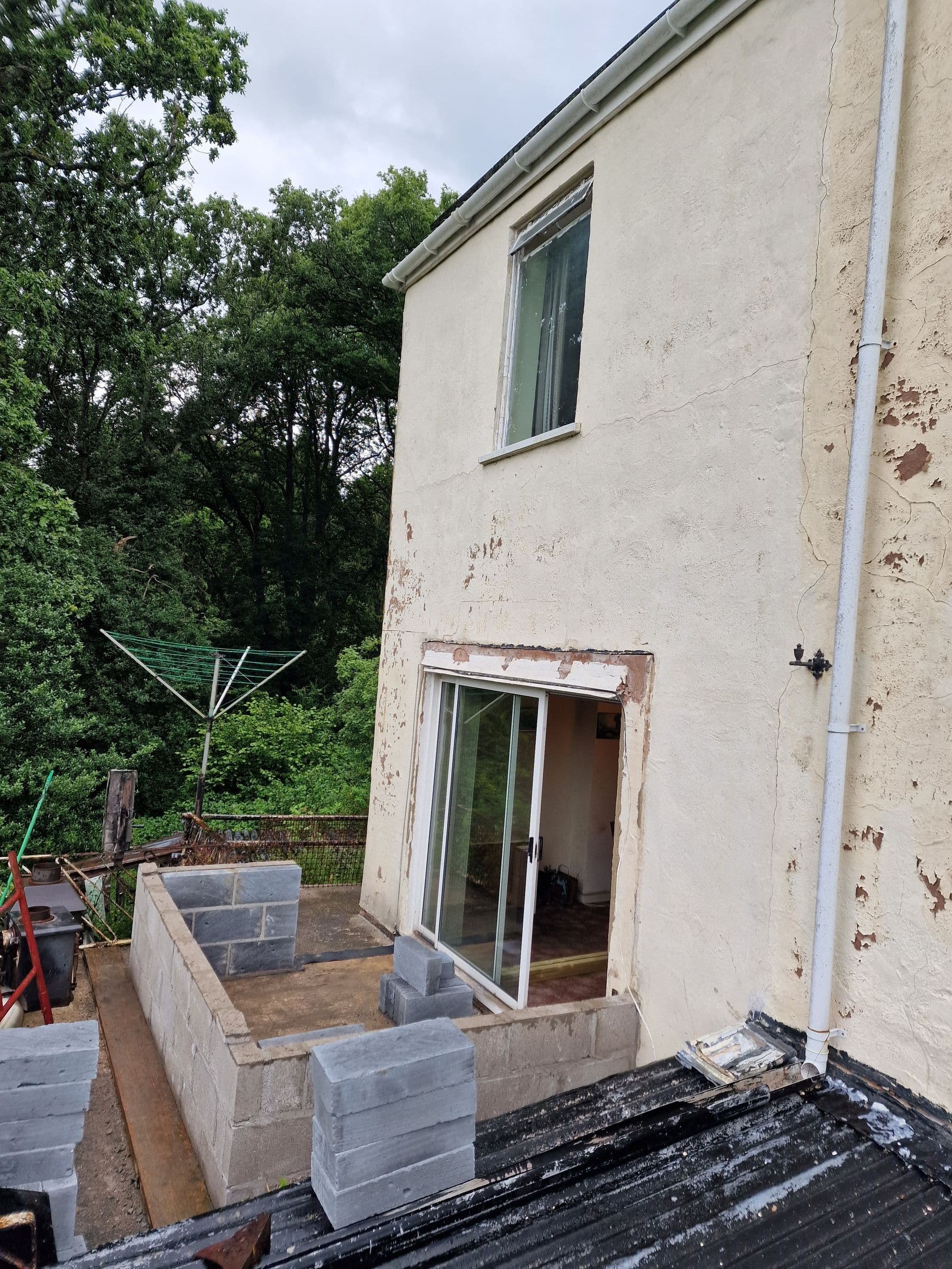 Blockwork walls of a single-storey rear extension going up outside a pair of sliding patio doors